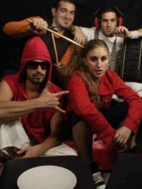 Tres personas vestidas de rojo en una escena cómica, con uno tocando un instrumento y dos mirando hacia la cámara.
