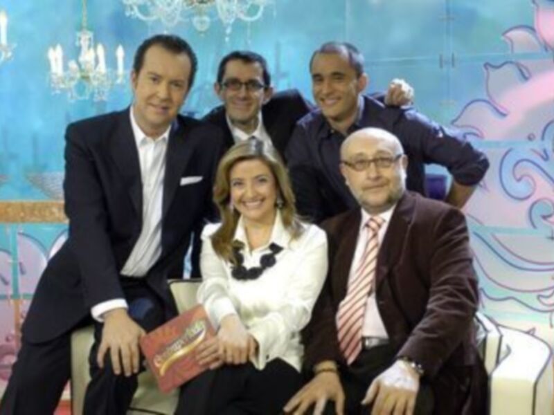 Entrevista grupal en un estudio con decoración acuática y sofás blancos.