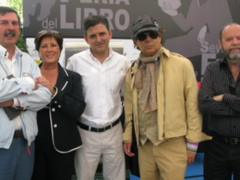 Grupo de personas posando frente a un cartel con el texto "Libro".