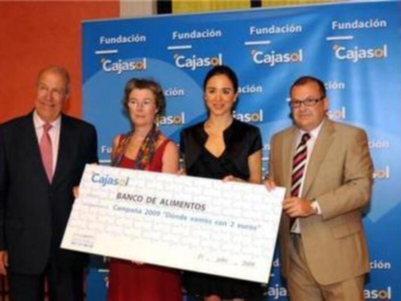 La Fundación Cajasol entrega un cheque a la campaña "Dando vamos 2 vueltas" en el Banco de Alimentos.