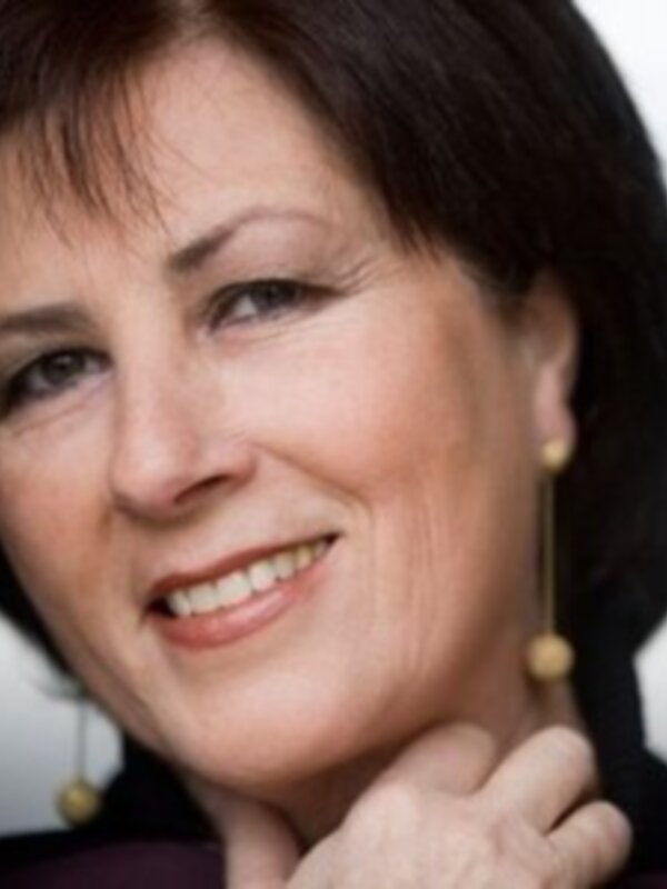 A una persona con cabello oscuro cortado y orejas doradas, posiblemente en un evento formal.