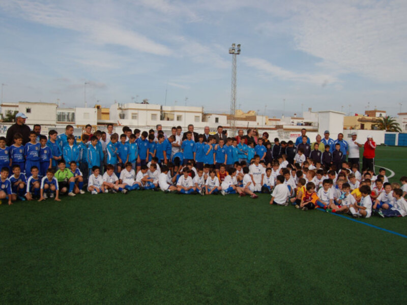 Equipo infantil de fútbol posando en un campo de juego.