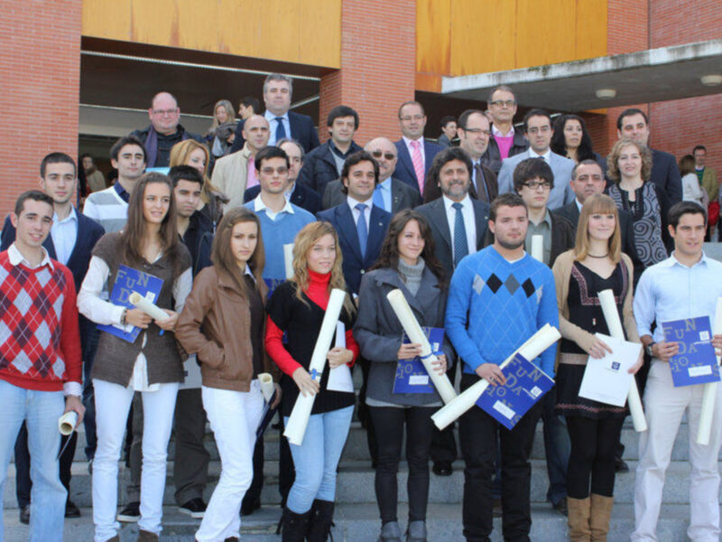 Estudiantes posan con diplomas en un evento académico.