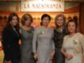 Una grupo de mujeres posando frente a un mural que dice "LA MAESTRANZA".