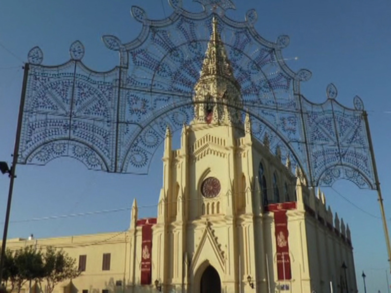 Iglesia con decoración navideña y arco ornamental en un día soleado.