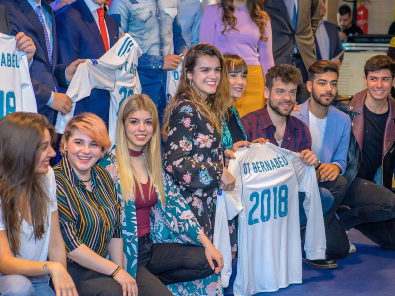 Grupo de jóvenes posando con una camiseta del Real Madrid 2018.