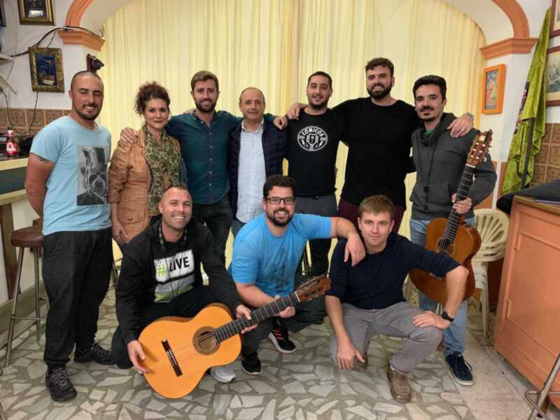 Grupo de amigos toca guitarras en una sala con decoración tradicional.