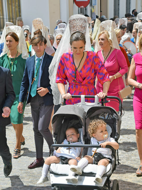 Imaginación en el evento, con personas vestidas de manera formal y un bebé en una silla de paseo.