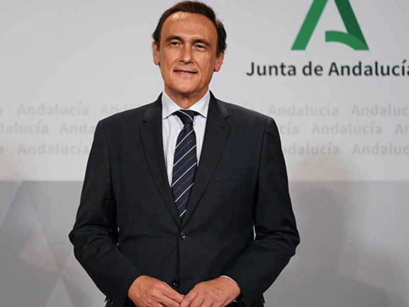El presidente de la Junta de Andalucía, Francisco de la Torre, posa frente a una pantalla con el logo de Andalucía.