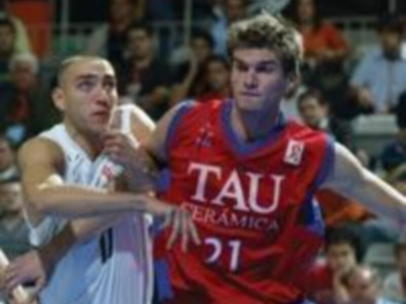 Dos jugadores de baloncesto en acción, uno con camiseta roja y otro con blanco.