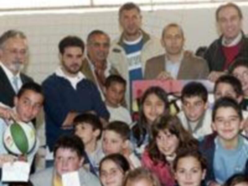 Una foto de grupo con varias personas, incluyendo niños y adultos, posando juntos. Algunos están sonriendo y otros miran hacia la cámara. La imagen parece ser de una reunión o evento familiar o social.