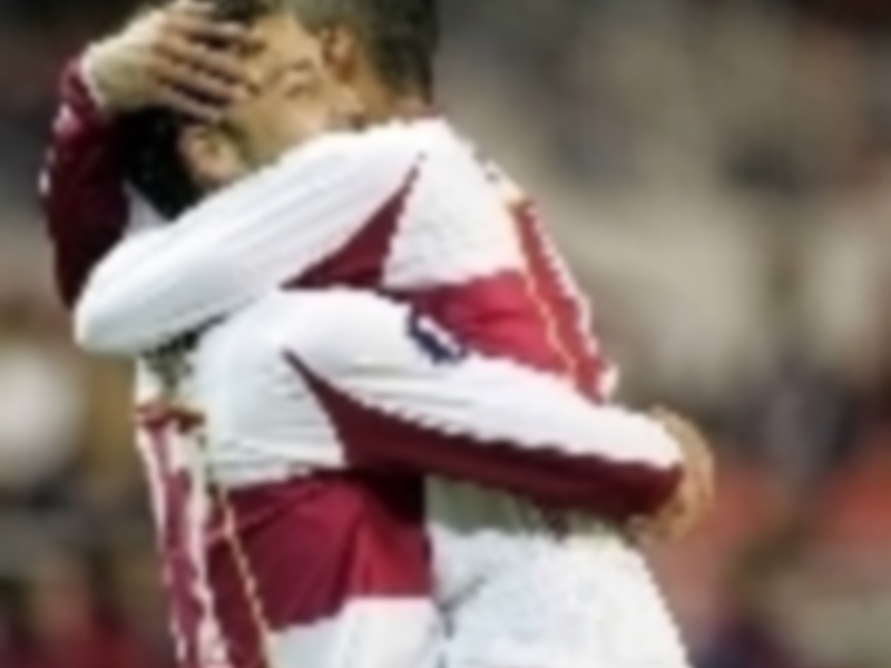 Un jugador de fútbol con una camiseta roja y blanca, posiblemente celebrando un gol o emocionado por una anotación.