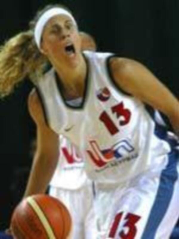 Una jugadora de baloncesto con el número 13 en su camiseta, luchando por controlar un balón rojo.