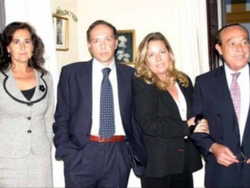 Una imagen de cuatro personas posando juntas, tres hombres y una mujer. La escena parece ser formal o profesional, posiblemente en un evento o reunión.