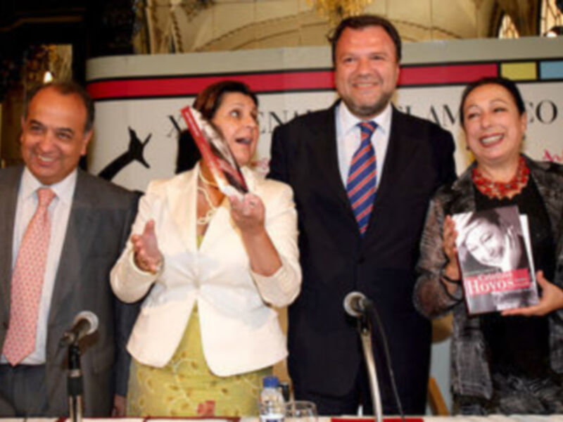 Celebración en Sevilla 2006, con una mujer sonriendo mientras sostiene un libro.