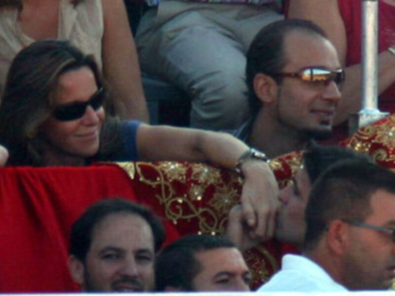Una mujer con gafas de sol y una camiseta azul, junto a un hombre con gafas de sol y una chaqueta roja.