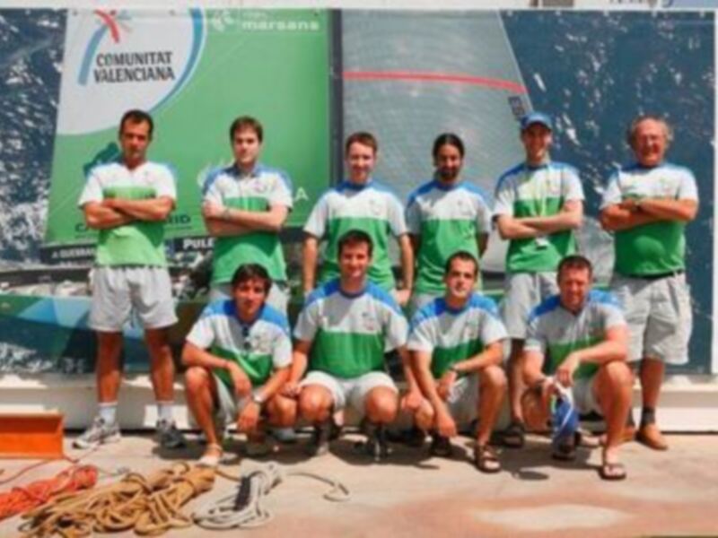 Equipo de fútbol en la Comunitat Valenciana, posando frente a una bandera.