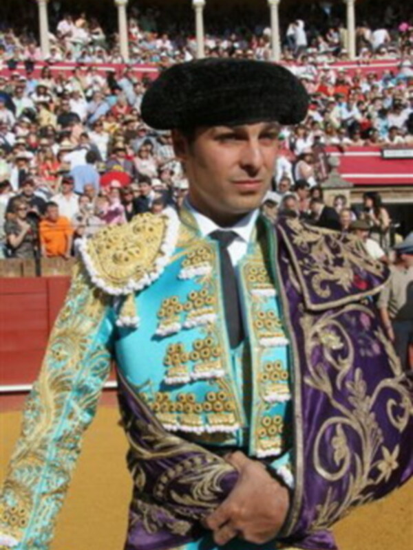 Un torero en traje de lujo durante una corrida de toros.