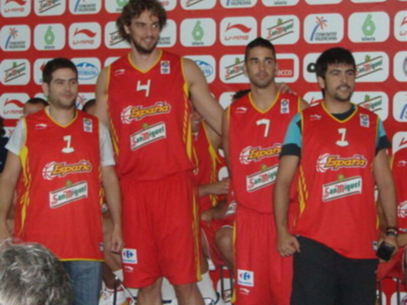 Los jugadores del equipo español de baloncesto celebran junto a su campeón, posando para una foto en el estadio.