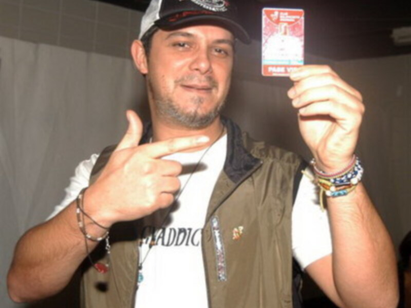 Un hombre sostiene una tarjeta de identidad mientras señala con el dedo índice.