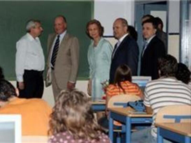 Profesores y estudiantes en una clase, con una pizarra en el fondo.