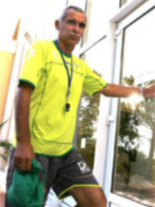 Entrenador deportivo sosteniendo una bolsa de equipo al aire libre.