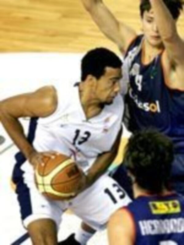 Un jugador de baloncesto en acción, con el número 13 en su camiseta, luchando por un balón mientras otros jugadores lo observan.