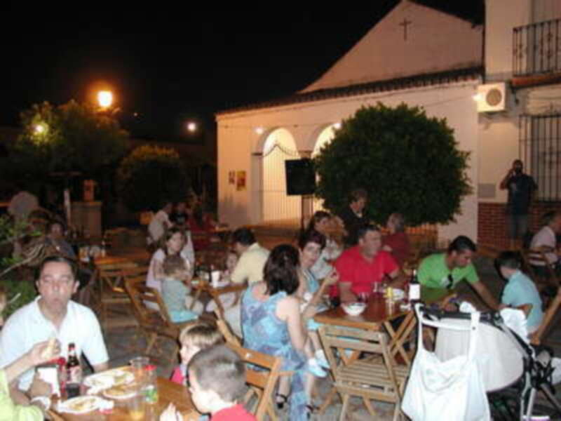 Familia y amigos disfrutando de una cena en un restaurante nocturno, con luces y ambiente festivo.