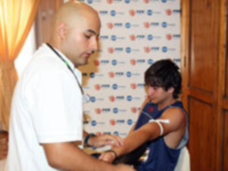 Un hombre en camiseta blanca y otro niño en azul firman un contrato. Fondo con logotipos de empresas.