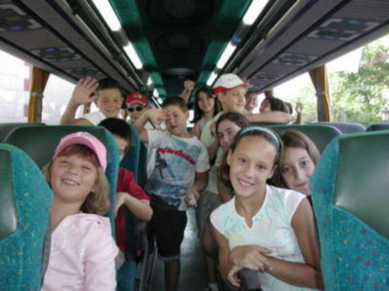 Niños felices en un autobús, disfrutando de su viaje.