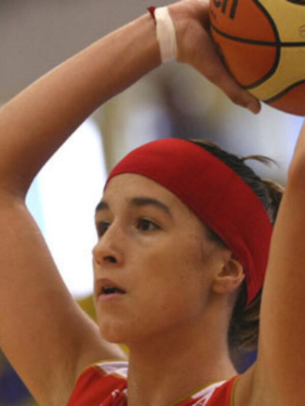 Joven jugadora de baloncesto en acción, concentrada mientras prepara un tiro.