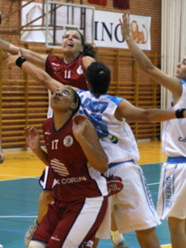 Fotografía de un partido de baloncesto femenino, con jugadoras en acción y el logo de la marca de baloncesto 'Corin' en el fondo.