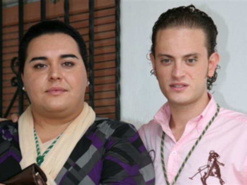 Dos personas posando juntas, una con un atuendo tradicional y la otra con ropa casual.