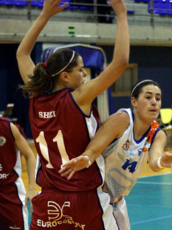 Jugadoras en un partido de baloncesto femenino, con una jugadora del equipo rojo con el número 11 y otro en blanco con la letra H.