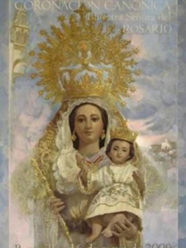Una coronación canónica de la Virgen del Rosario, celebrada en Burguiillos el 16 de mayo de 2009. La Virgen sostiene a un niño, y la escena está rodeada por un cielo azul con nubes blancas.