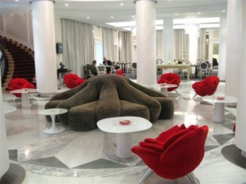 Sala de estar moderna con sofá cómodo en forma única y sillas rojas.