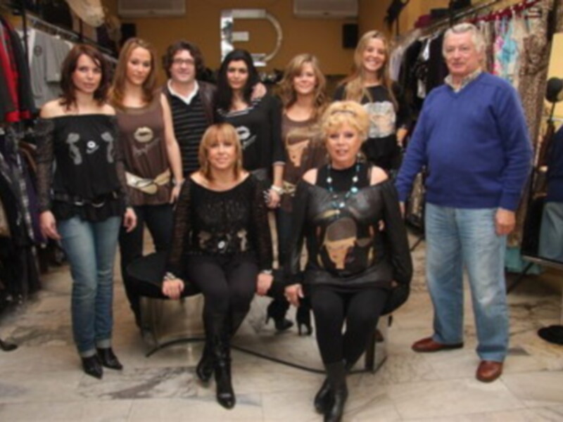 Una imagen de varias personas posando en un escaparate de ropa, con estilos únicos y una variedad de prendas.