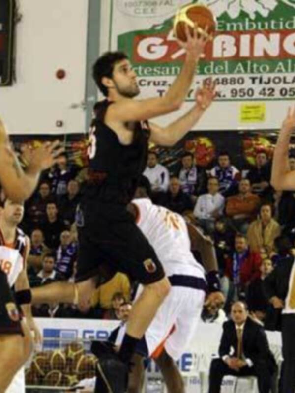 Un jugador de baloncesto en acción durante un partido, con el escudo de la marca 'Gabinio' visible en el fondo.