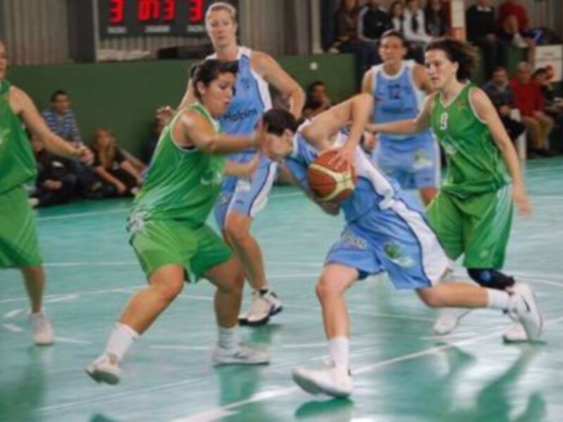 Equipo verde y azul en acción durante un partido de baloncesto.