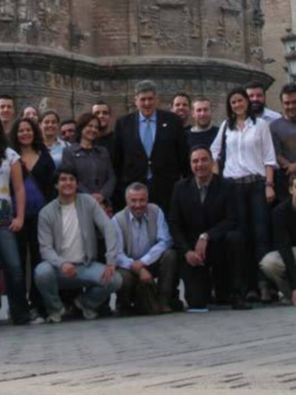Grupo de personas posando para una foto en un entorno urbano, posiblemente en un evento o reunión formal.