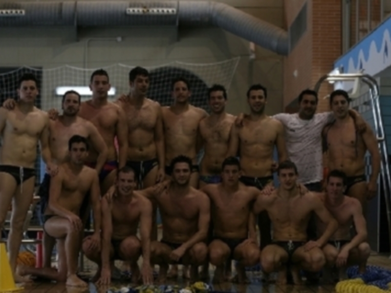 Un grupo de hombres en trajes de baño posando para una foto en un estadio deportivo.