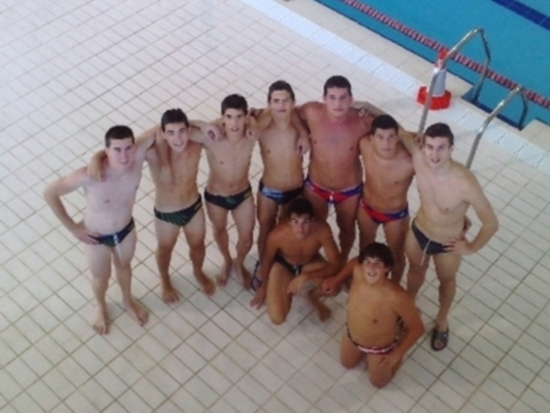 Un grupo de jóvenes posando en la piscina, todos vestidos con trajes de baño.