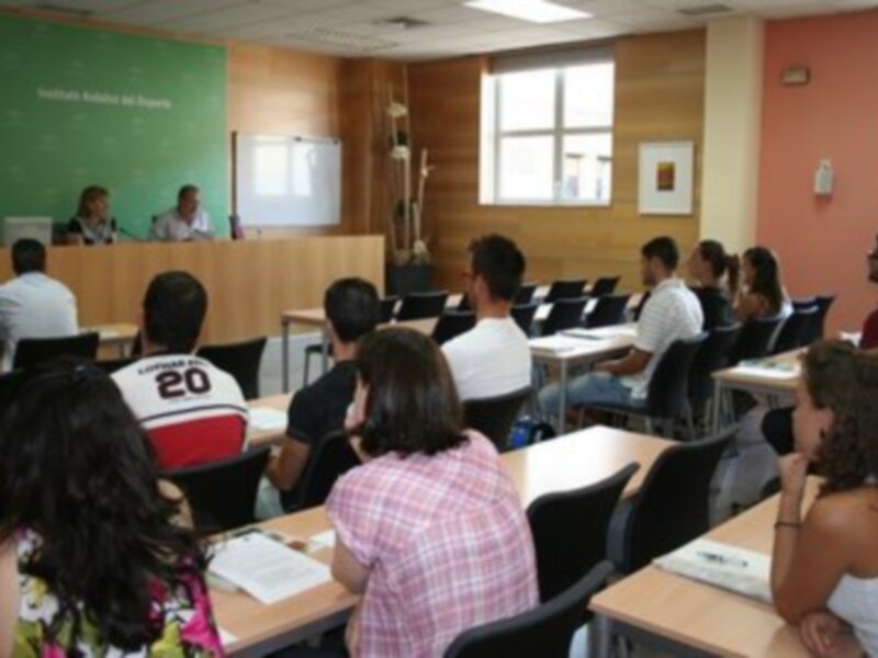 Alumnos escuchando a un profesor en una clase de idiomas.