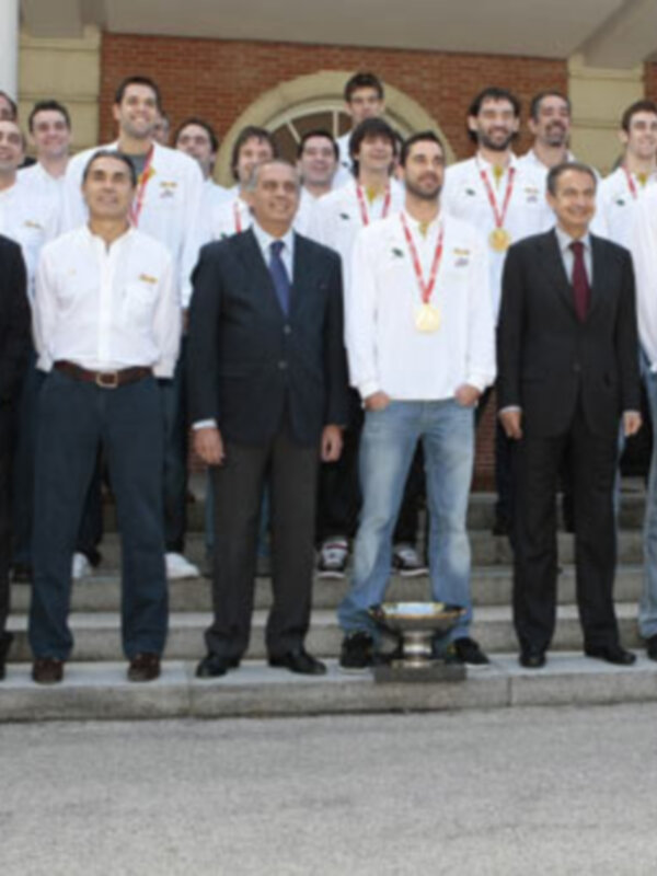 Equipo deportivo celebrando un logro con sus medallas y trofeo.