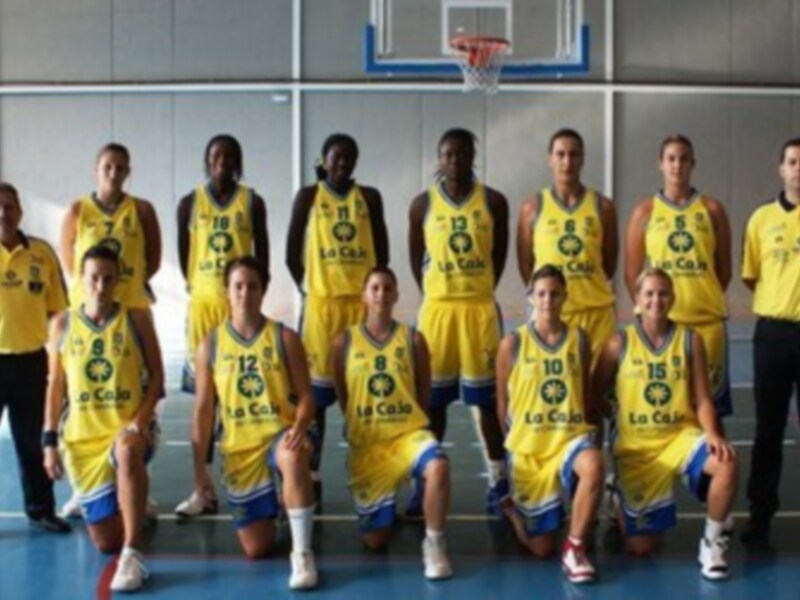 Equipo de baloncesto en uniforme amarillo con el nombre 'La Cie' en el escudo, posando en el gimnasio.