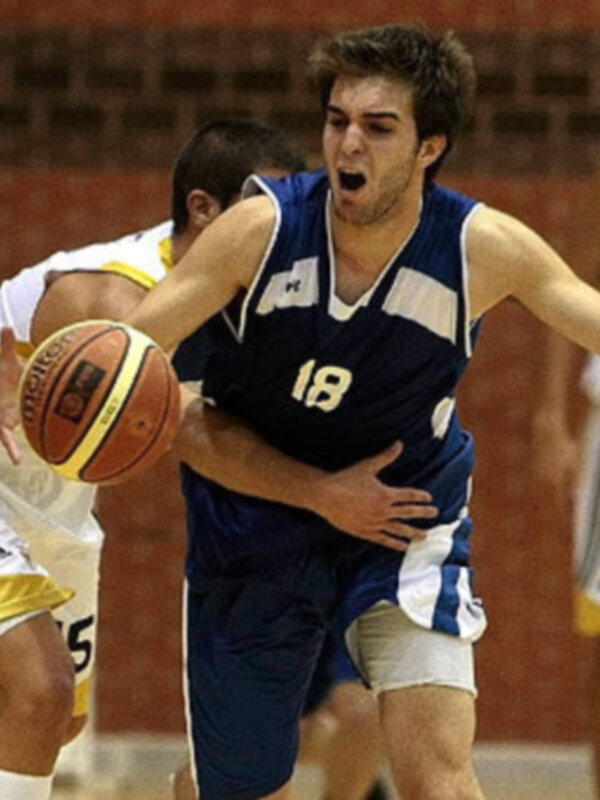 Un jugador de baloncesto en acción durante un partido, con el número 18 destacado en su camiseta.