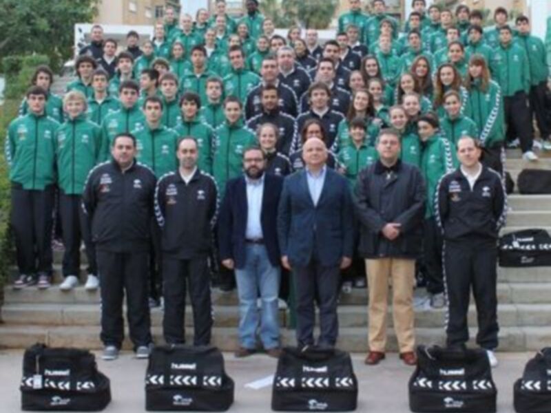 Equipo de fútbol posando para una foto en la entrada de un edificio.