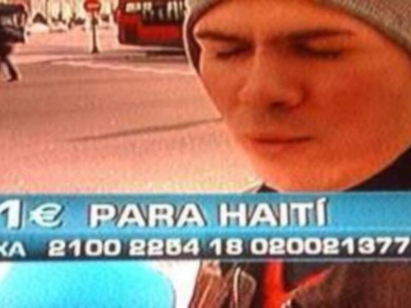 Un hombre en una calle con un anuncio de "1€ para Haití" y detalles bancarios.