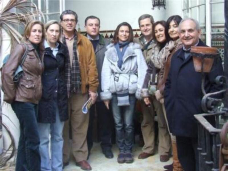 Una reunión de trabajo en un edificio histórico, con personas vestidas de manera formal y una persona con un abrigo de invierno.