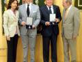 Los hombres están recibiendo premios en un ambiente formal, posiblemente una ceremonia o evento oficial.
